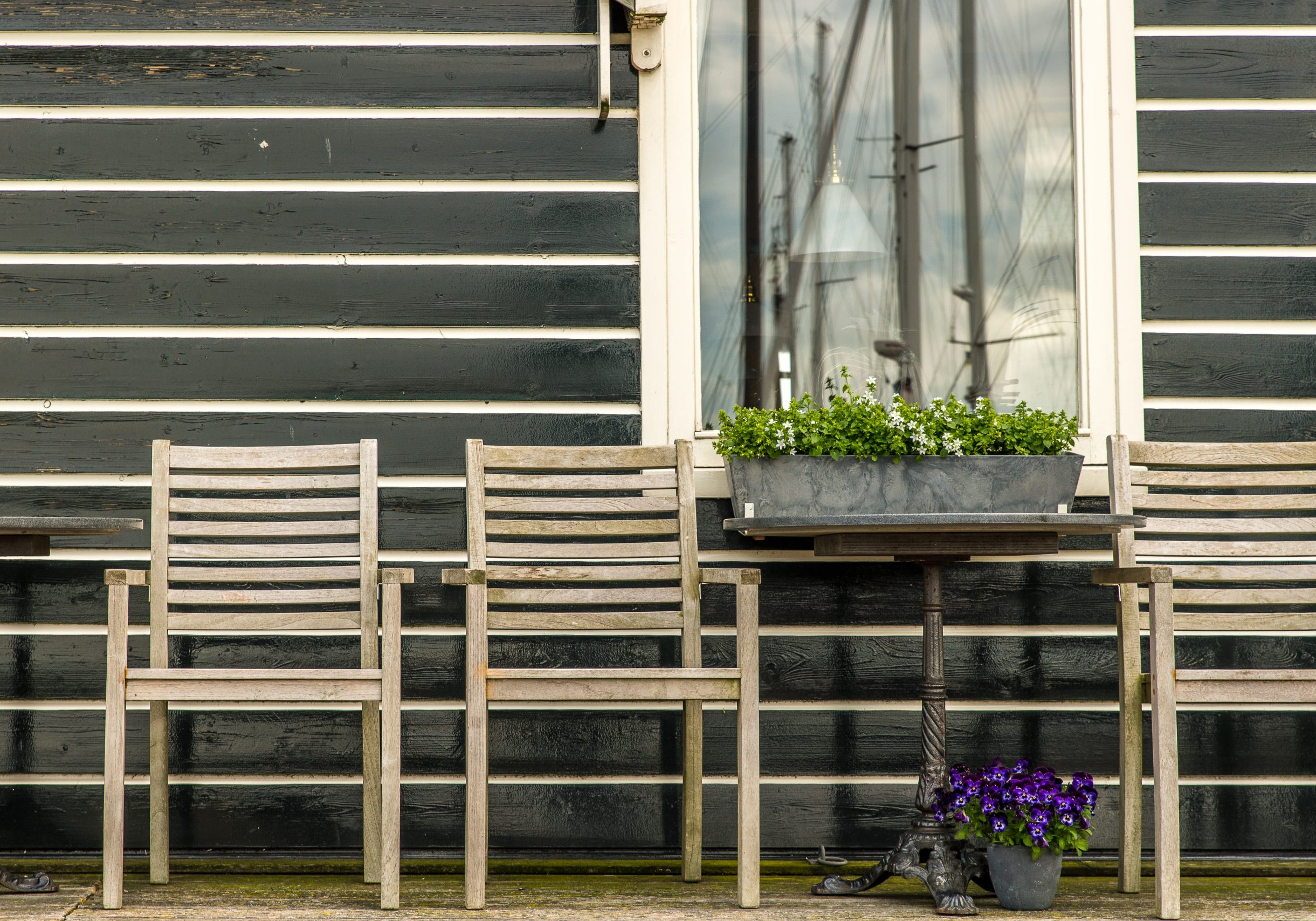 A beautiful shot of wooden chairs on the porch of a wooden house